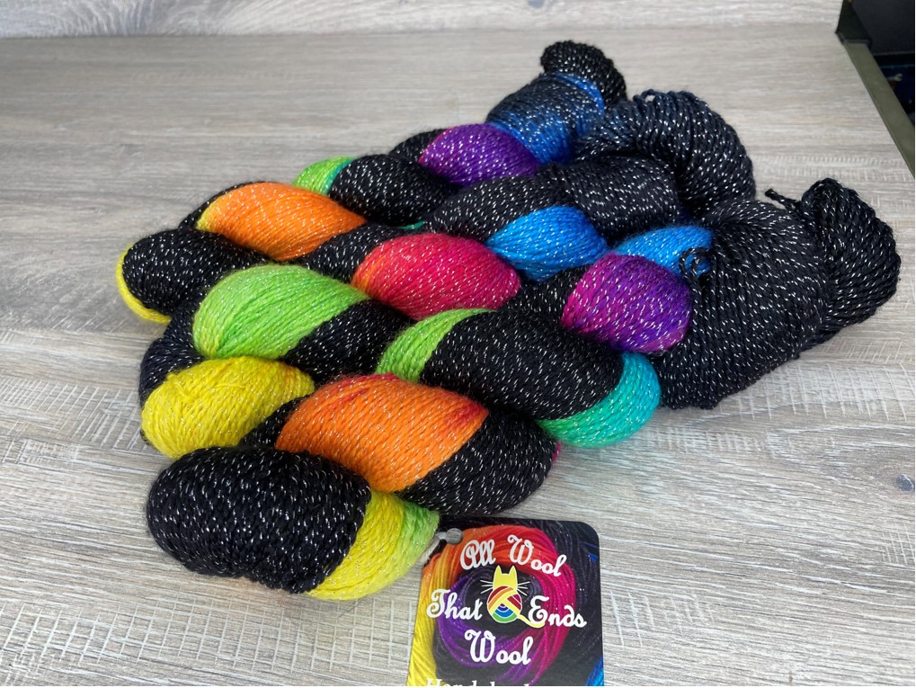 3 skeins of sparkly black yarn with rainbow shades running through