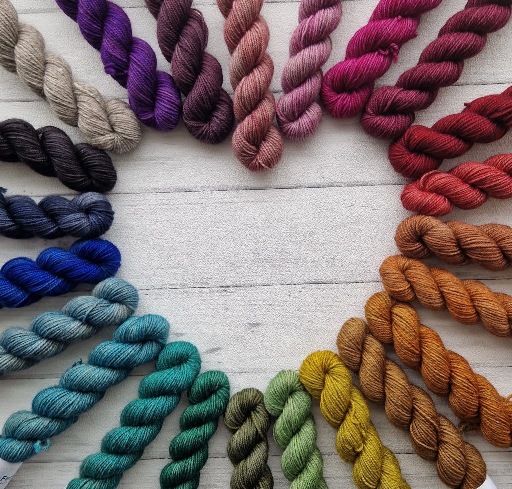 24 skeins of yarn in all shades of the rainbow, arranged in a heart shape 