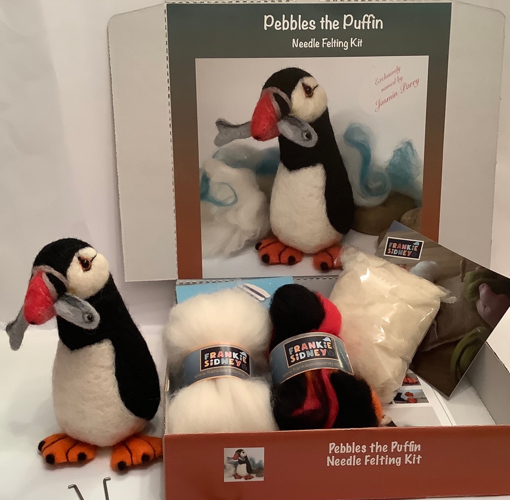 a needle felted puffin kit with a needle felted puffin called Pebbles standing beside it 