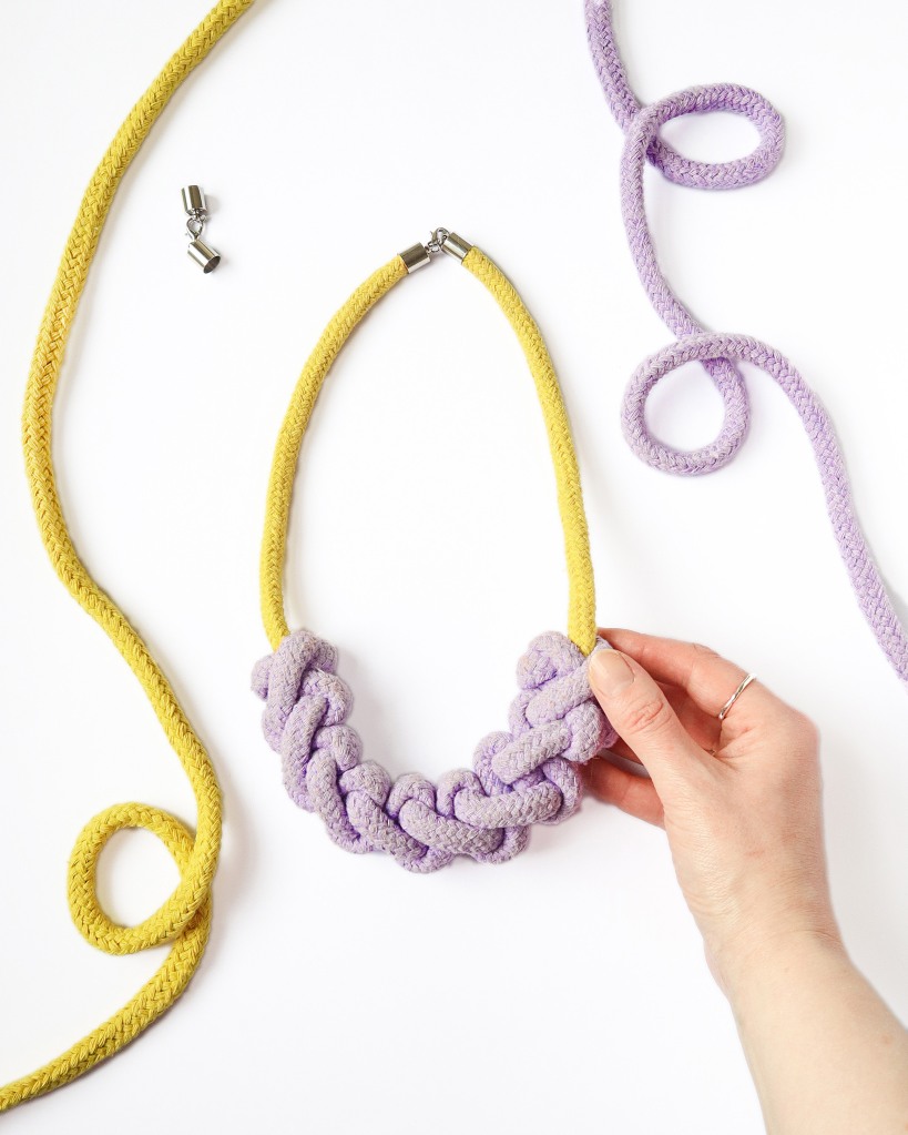 a macrame necklace in purple and yellow 