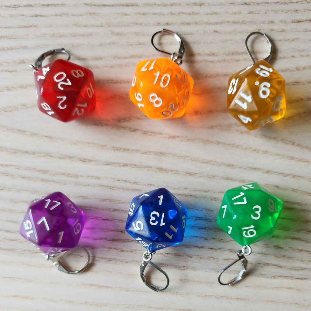 6 stitch markers depicting many-sided die on a wooden surface