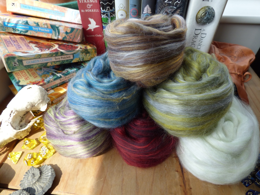 a pyramid of roving yarn in various shades on a table 